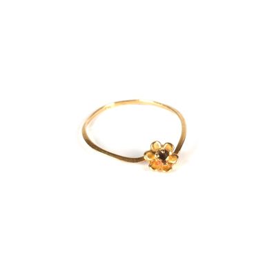 Gros plan sur une bague en or ornée d'une fleur