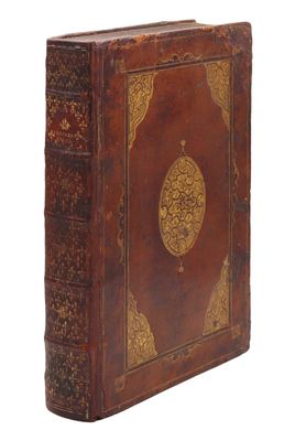 un vieux livre relié en cuir dont la couverture est ornée de motifs élaborés