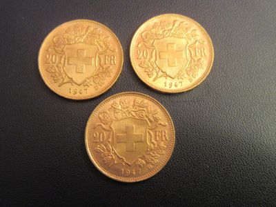 trois pièces d'or posées sur une surface noire