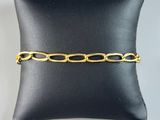 a black pillow with a gold chain bracelet on it