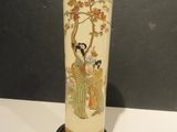 a vase with a painting on it sitting on a table
