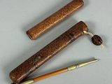 two pens and a pen holder on a table