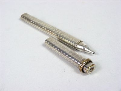 un stylo en argent et un stylo en argent posés sur une surface blanche