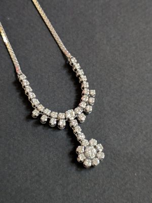 a diamond cross necklace on a black surface