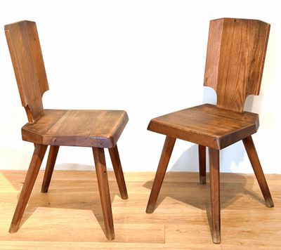 two wooden chairs sitting next to each other on a hard wood floor