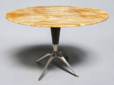 un gros plan d'une table avec un plateau en marbre et des pieds en métal