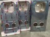 trois paquets de papier toilette emballés dans du plastique, posés par terre