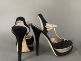 pair of black and white high heeled shoes with bows on the toes