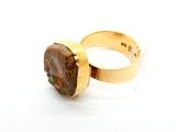 bague en or jaune sertie d'une pierre brune au centre