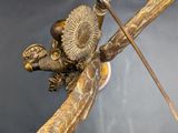an antique bronze figurine of a boy with a bow and arrow