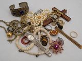 a pile of jewelry on a table with a cross