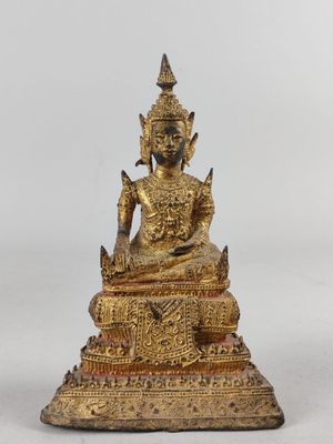 une statue en or représentant un Bouddha assis sur une table