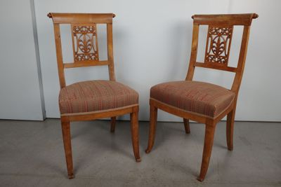 deux chaises en bois avec des assises rembourrées à motifs dans une pièce