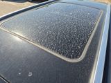 cars parked in a parking lot with snow on top of the roof