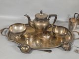 a silver tea set on a silver tray with silver cups and spoons