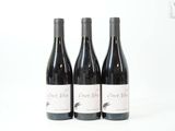 trois bouteilles de vin posées sur une table blanche