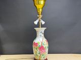 une lampe posée sur une table sur laquelle se trouve un vase