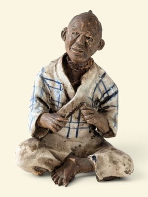 une figurine représentant un homme assis par terre