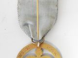an old medal with a silver ribbon on a white background