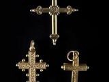 three gold crosses are shown against a black background