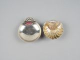 une paire de cuillères en argent ornées de coquillages, posées sur une table