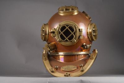 un casque de plongée ancien posé sur une surface blanche