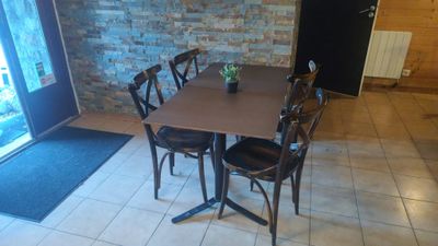 a table with chairs and a vase of flowers on it