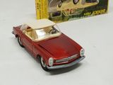 a red toy car sitting next to a box of toys
