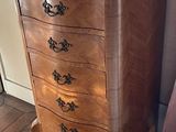 a small chest of drawers in the corner of a room