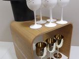 quatre verres à vin et un chapeau haut-de-forme posés sur un socle en bois