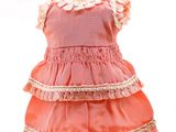 une robe rose posée sur un présentoir à mannequin, sur fond blanc