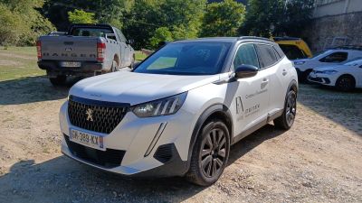 un SUV blanc garé sur un terrain en terre battue