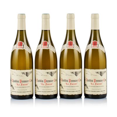 three bottles of white wine are lined up on a white surface