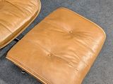 a brown leather chair and ottoman in a room