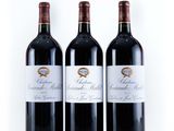 three bottles of red wine sitting next to each other on a white surface