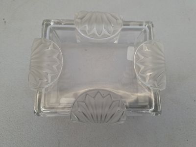 un cendrier en verre transparent posé sur une table blanche