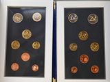 two framed pictures of coins on display in a display case