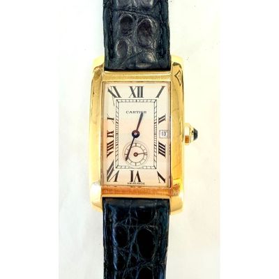 une montre en or avec des chiffres romains, montée sur un bracelet noir