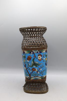 un vase bleu orné d'un oiseau, posé sur une table