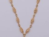 a gold plated necklace with a large pendant on a chain