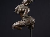 une statue en bronze représentant une danseuse, posée sur un socle en marbre