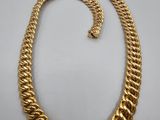 a gold necklace and bracelet set on a white background