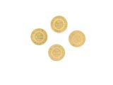 quatre pièces d'or sont disposées en cercle sur une surface blanche