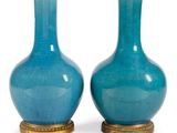 paire de vases en verre bleu avec des socles dorés sur fond blanc