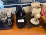 a coffee maker on the counter next to a cup of coffee