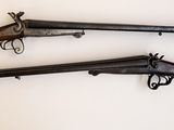 trois vieilles armes à feu sont exposées sur une surface blanche