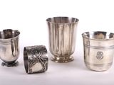 trois coupes en argent et une coupe en argent posées sur un fond blanc