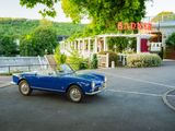une décapotable bleue garée devant un restaurant