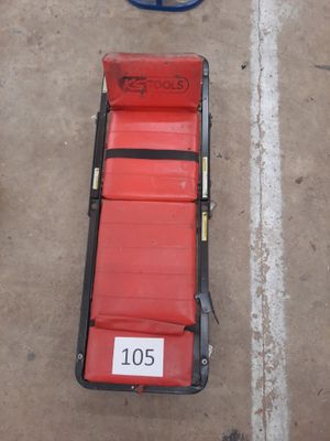 a red chair sitting on the ground next to a blue object