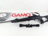 a close up of a rifle with a scope and a box of gamo